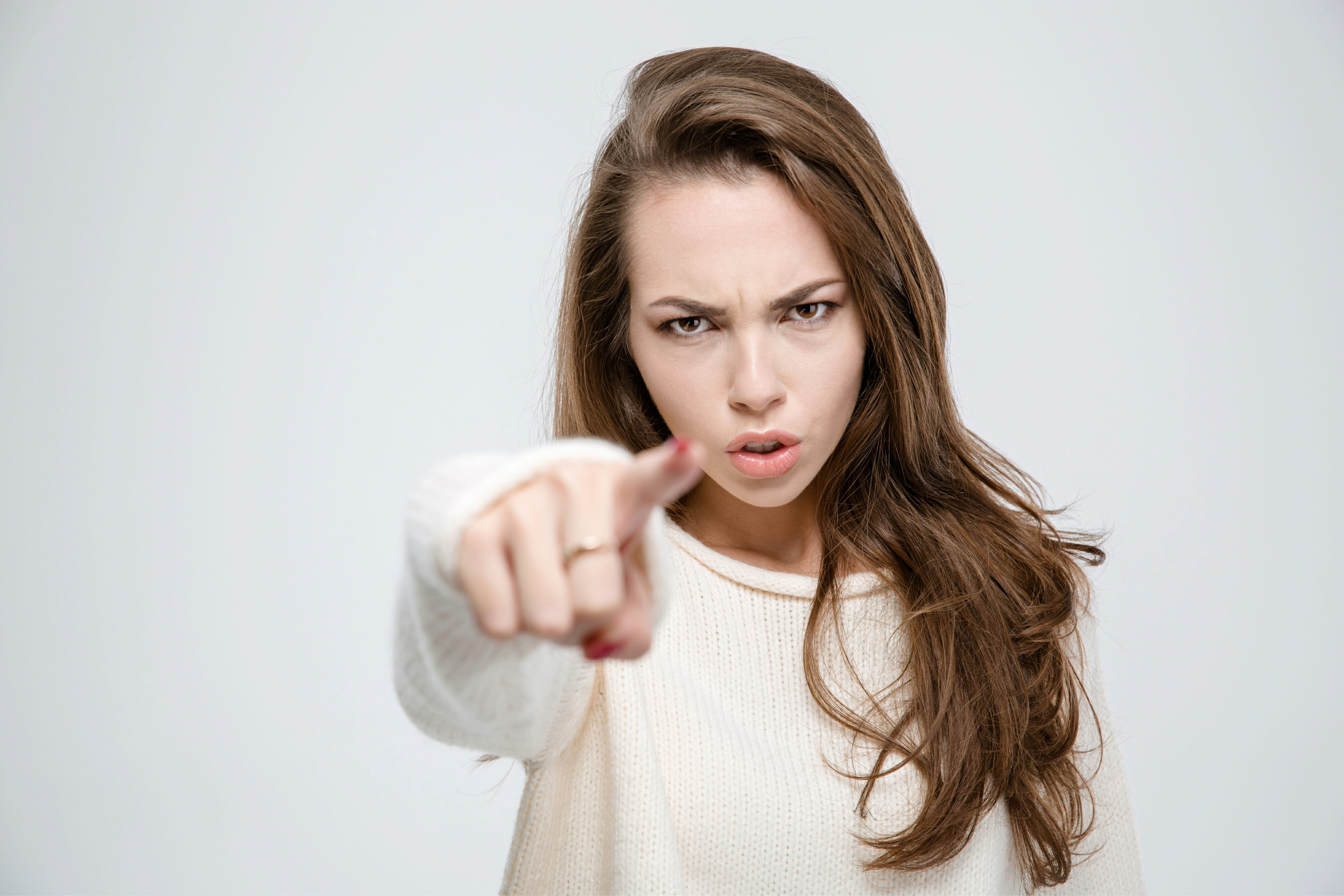 Angry woman pointing finger at camera