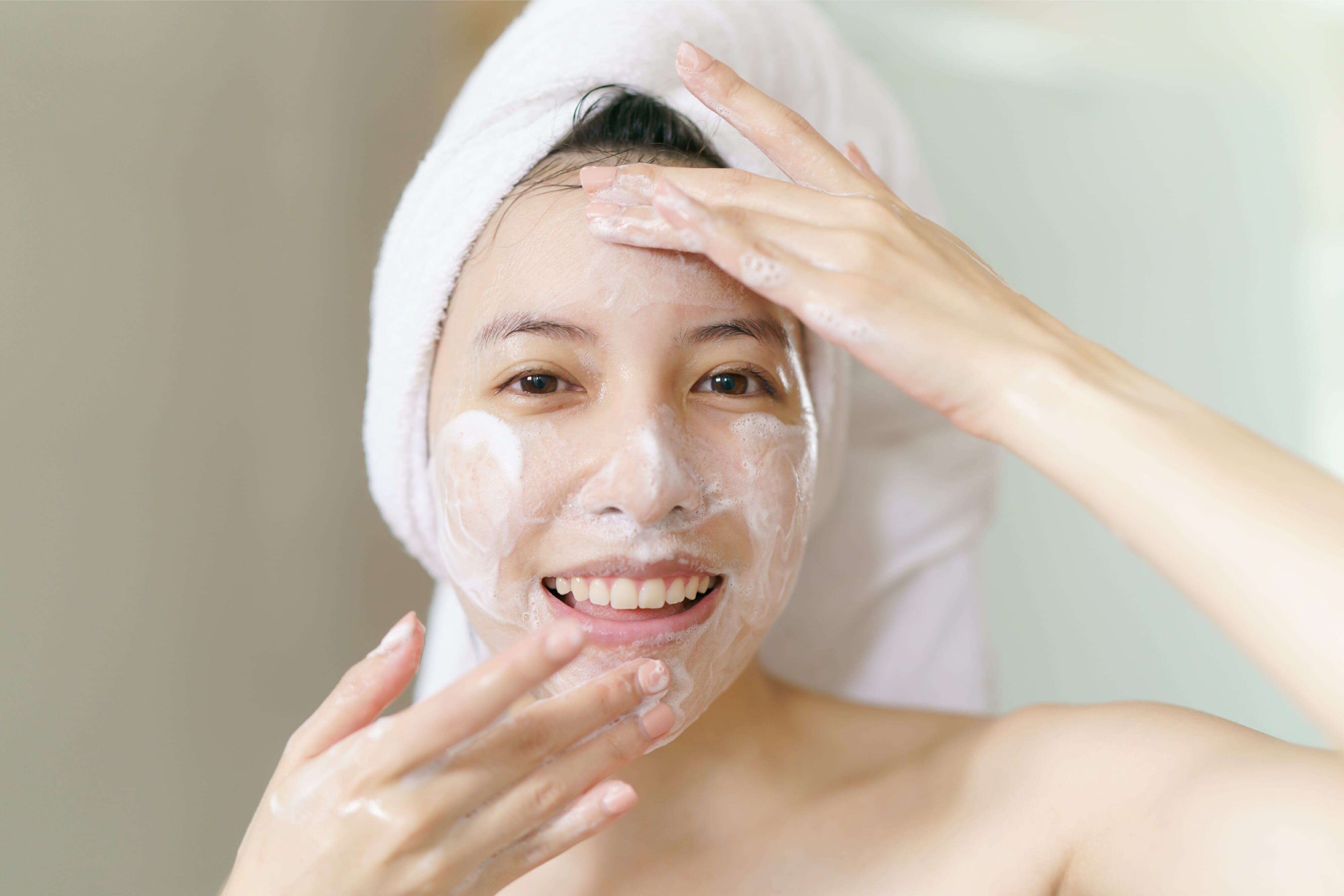 Woman washing face with foam cleanser