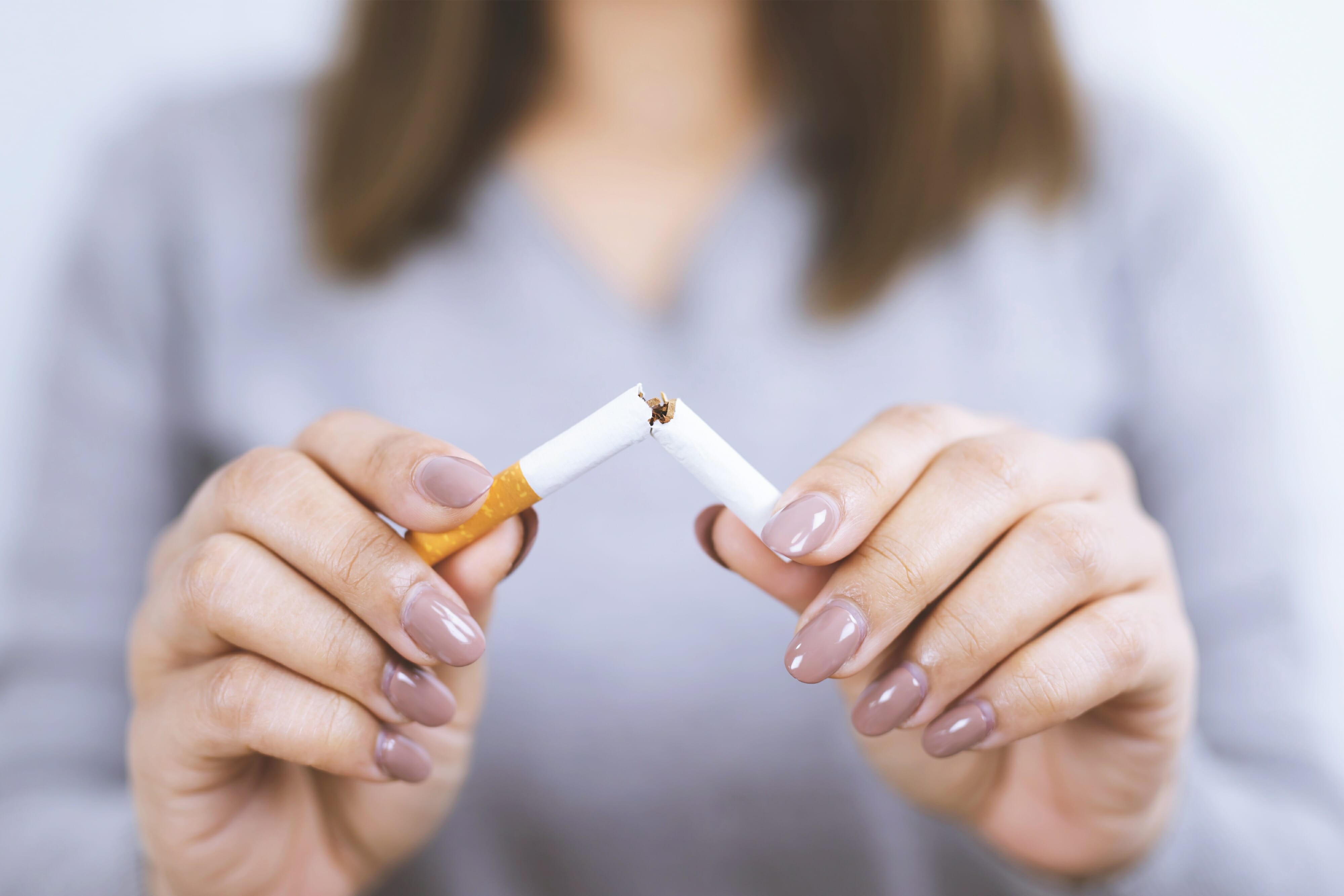 Woman refusing cigarettes concept for quitting smoking in hand