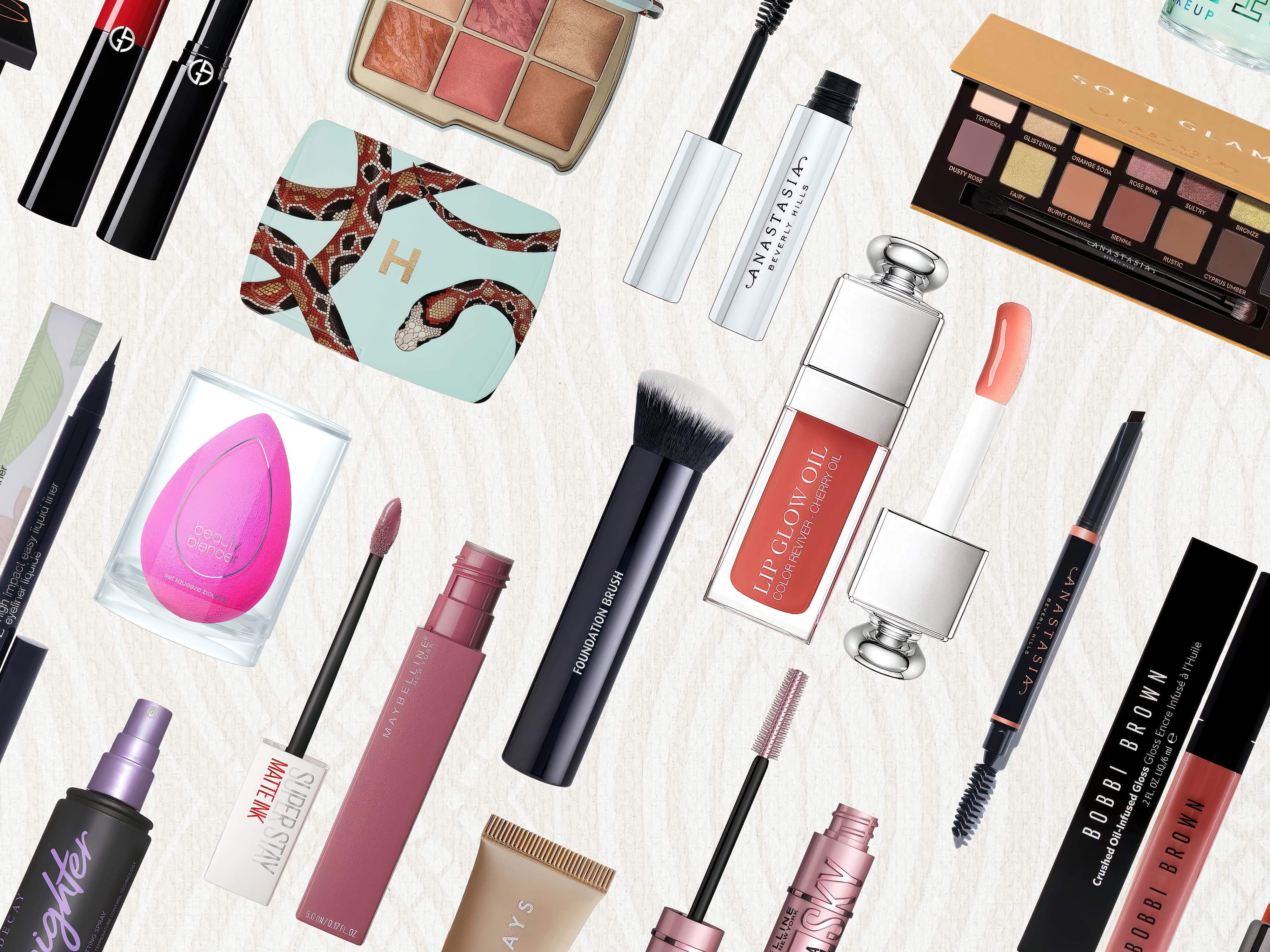 A group of the best makeup products, palettes, brushes and powders on a light cream background