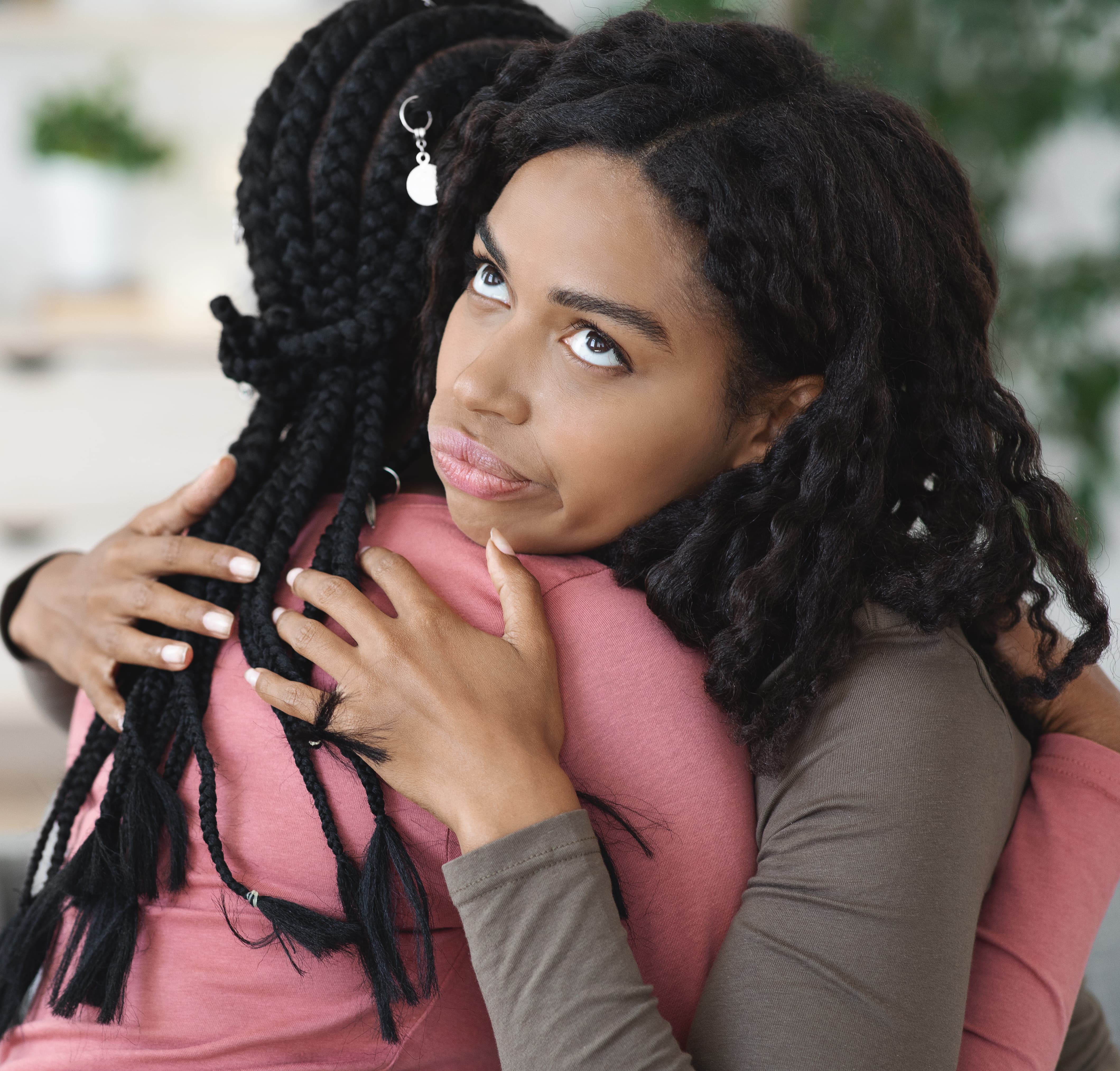 Irritated black lady hugging her girlfriend, fake friendship