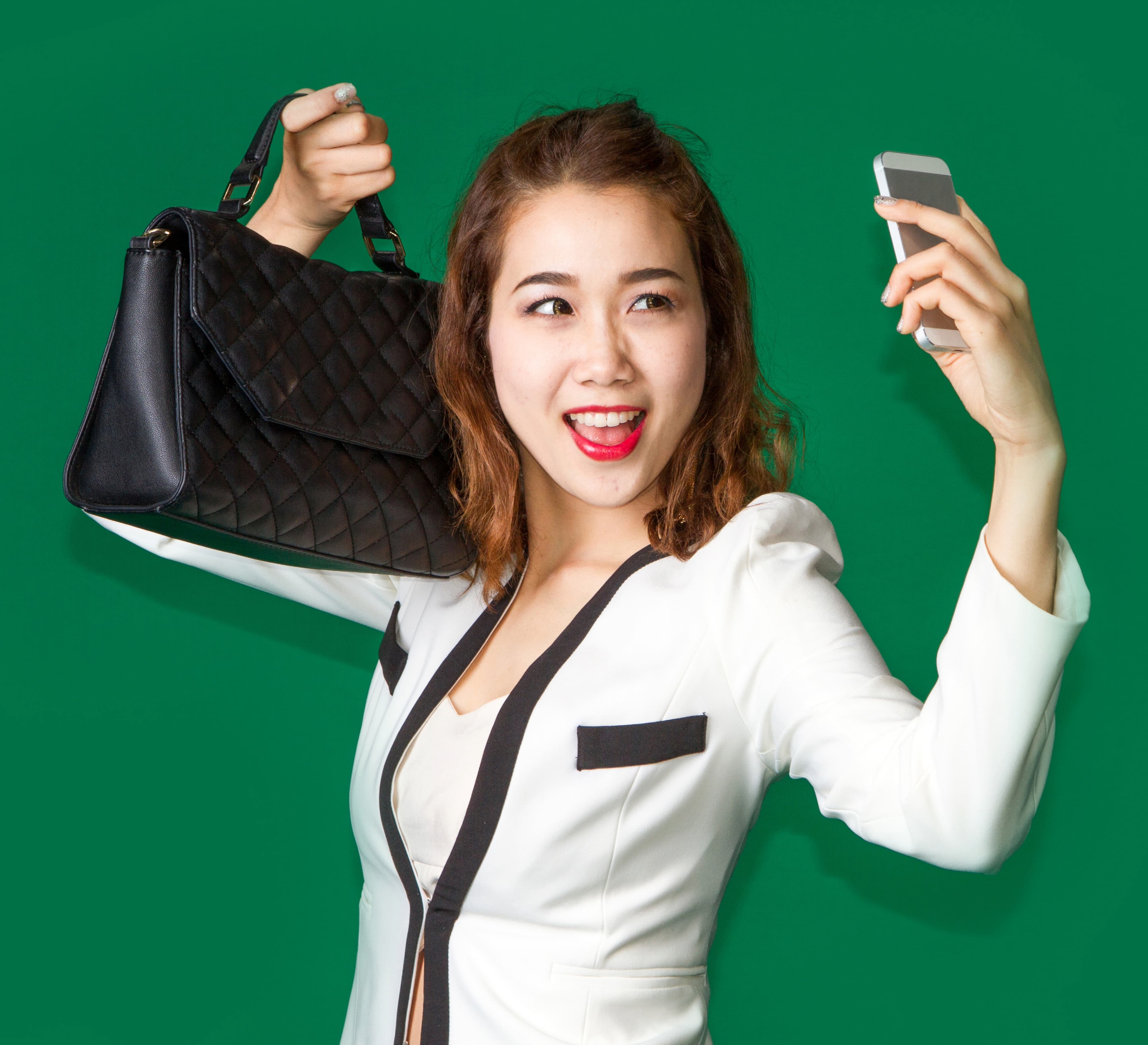 Lady show off her new purse by mobile phone