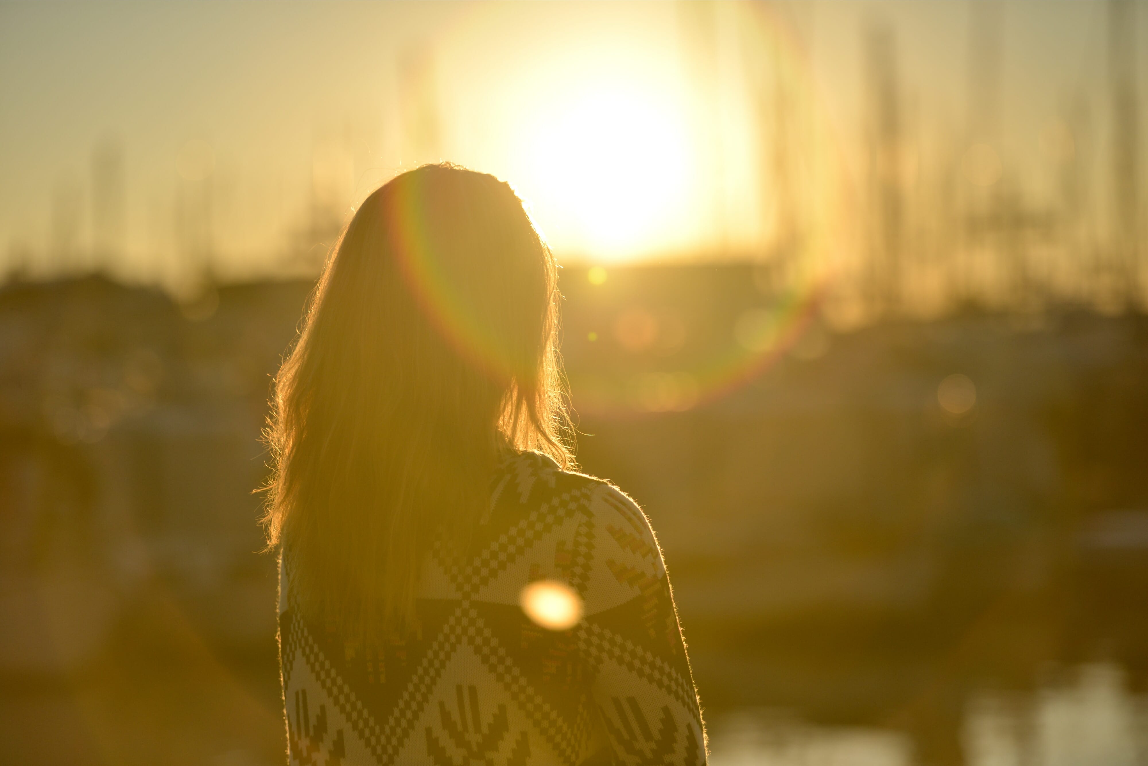 Woman standing against facing sun