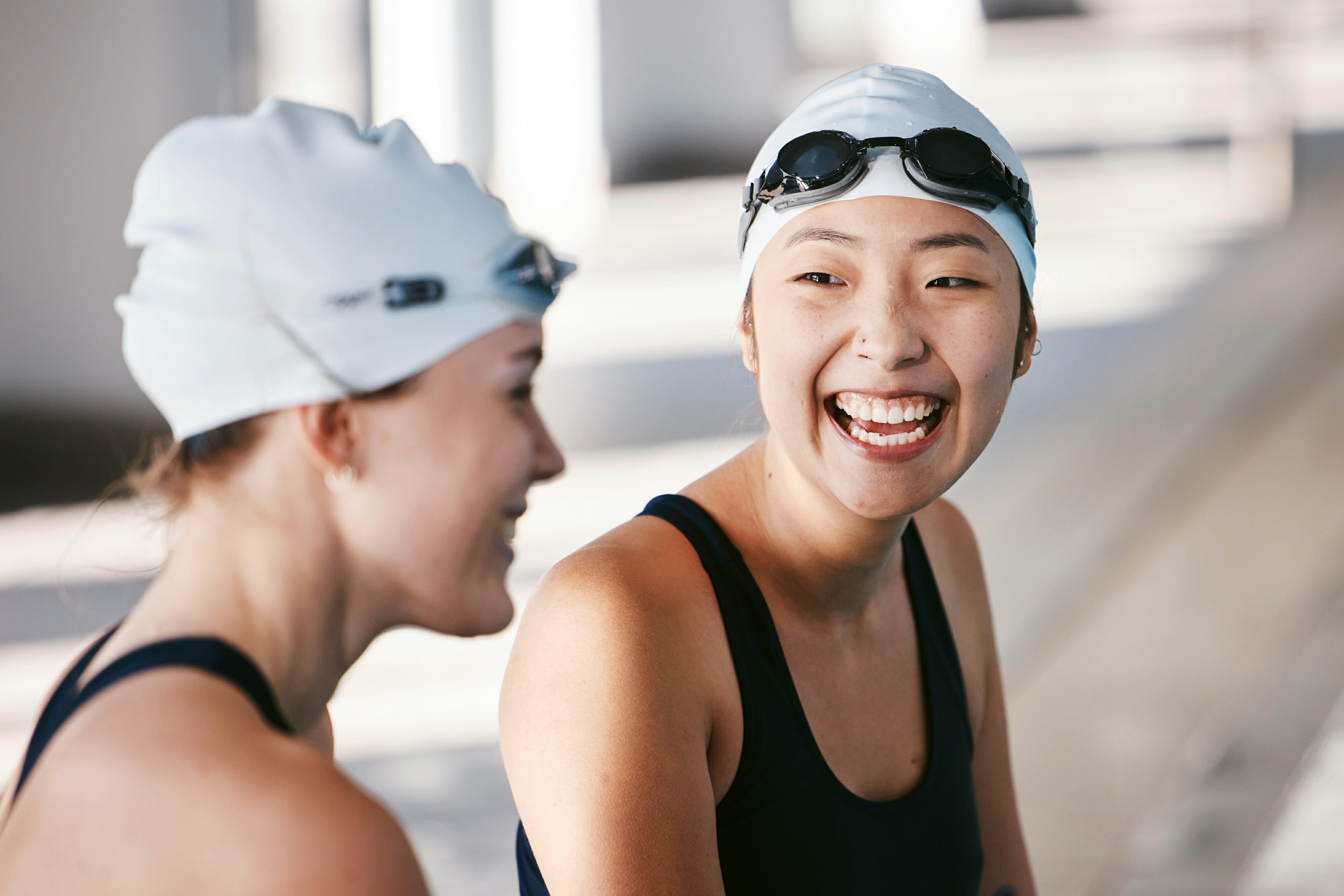 Female swimmers laughing and having fun during training in the swimming pool